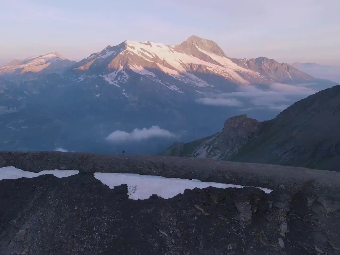 Les Alpes au-dessus du lac d'Annecy à l'aube, les crêtes qui s'allument une à une dans la lumière rasante.