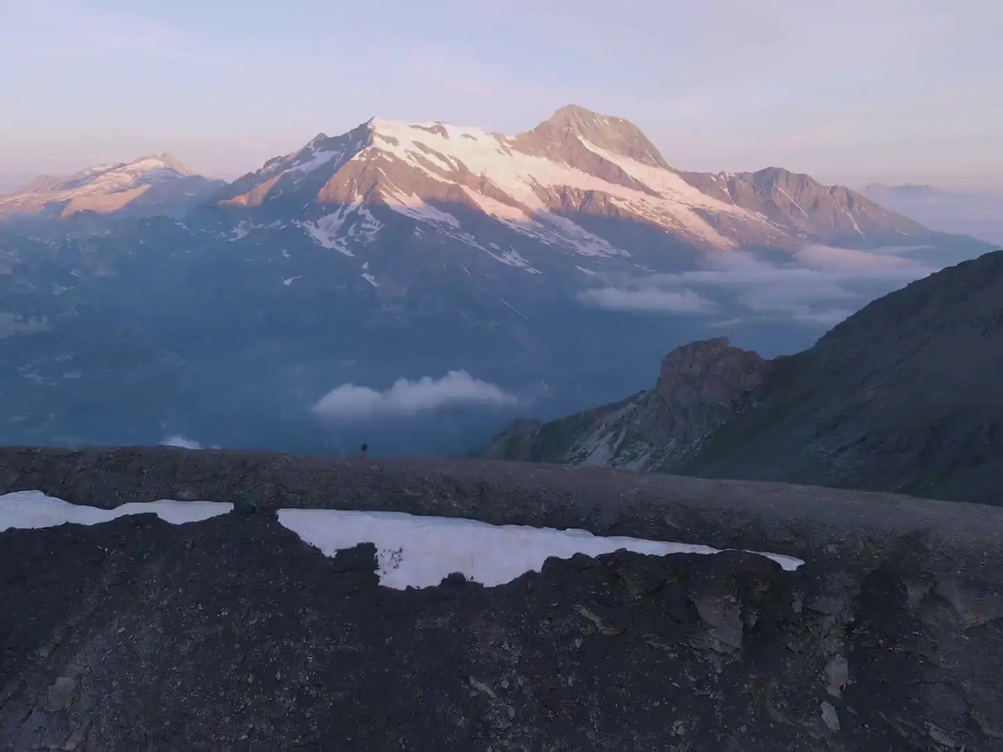 Les Alpes au-dessus du lac d'Annecy à l'aube, les crêtes qui s'allument une à une dans la lumière rasante.